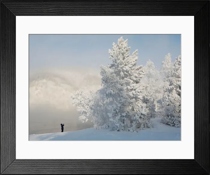 Framed Print : A woman takes pictures on a bank of the Yenisei River covered with snow and hoarfrost Framed Print : A woman takes pictures on a bank of the Yenisei River covered with snow and hoarfrost