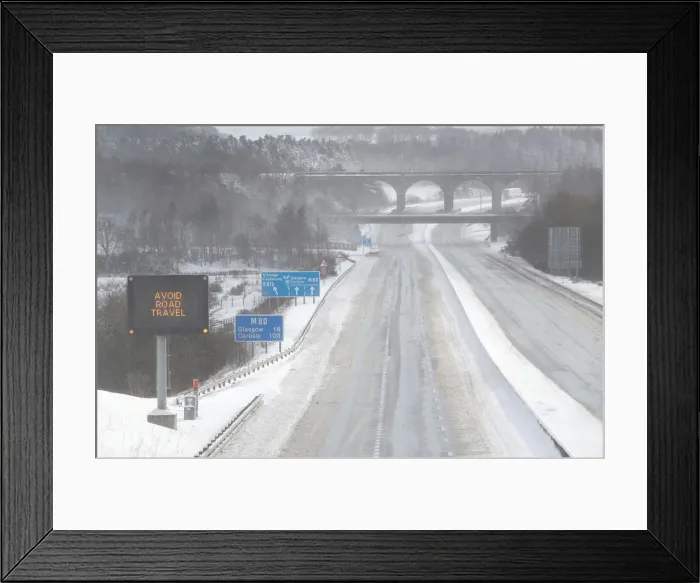 Framed Print : The M80 motorway is completely empty after being closed to clear vehicles stranded by bad Framed Print : The M80 motorway is completely empty after being closed to clear vehicles stranded by bad