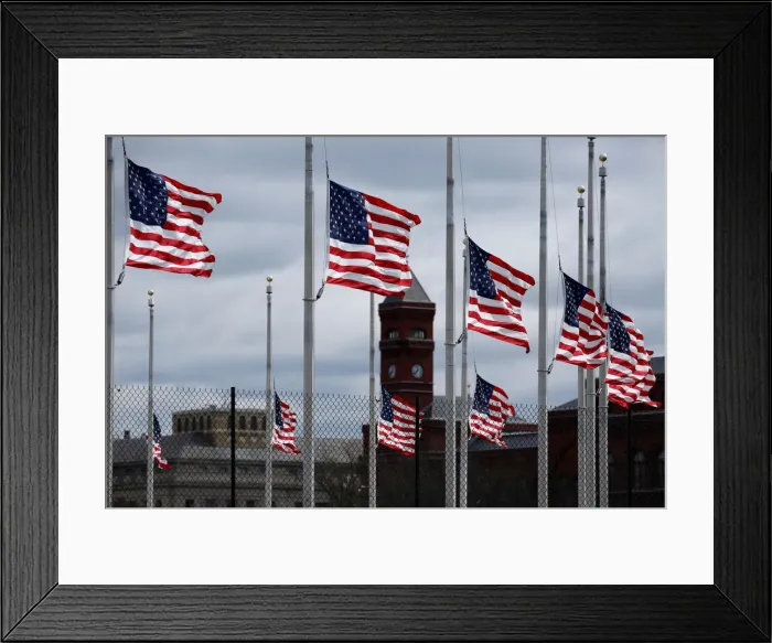 Framed Print : American flags fly as a storm producing strong winds passes through Washington