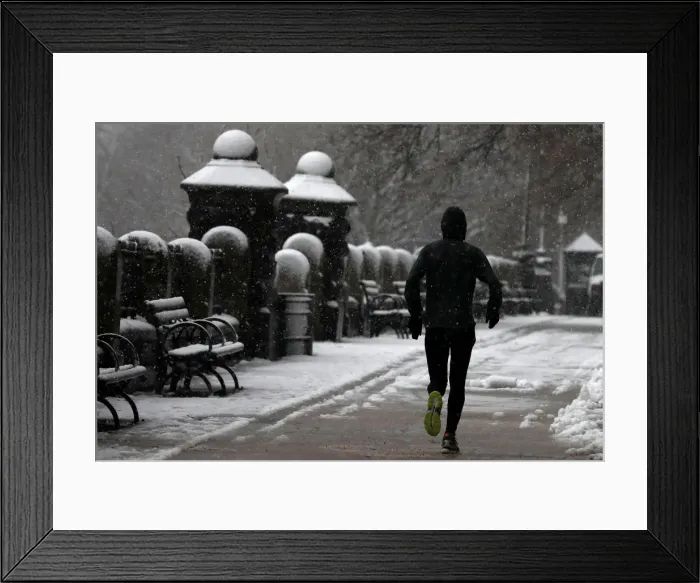 Framed Print : A man jogs during a snowstorm in upper Manhattan in New York City Framed Print : A man jogs during a snowstorm in upper Manhattan in New York City