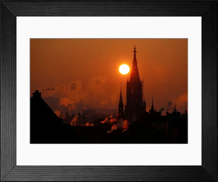 Framed Print : The sun rises behind the Muenster Cathedral during a cold morning in Bern Framed Print : The sun rises behind the Muenster Cathedral during a cold morning in Bern