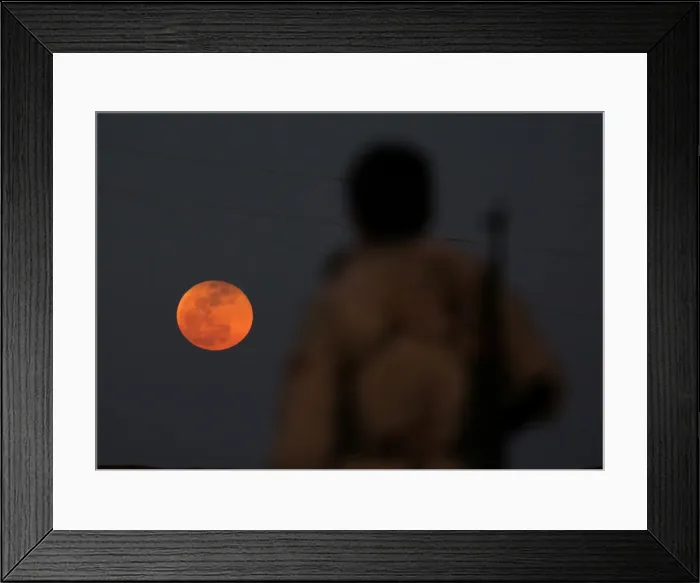 Framed Print : A fighter from Free Syrian Army is seen watching a full moon rises in Daraa Framed Print : A fighter from Free Syrian Army is seen watching a full moon rises in Daraa