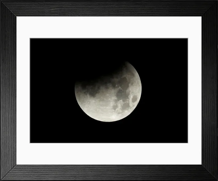 Framed Print : The start of a lunar eclipse is shown over the ocean in Oceanside, California