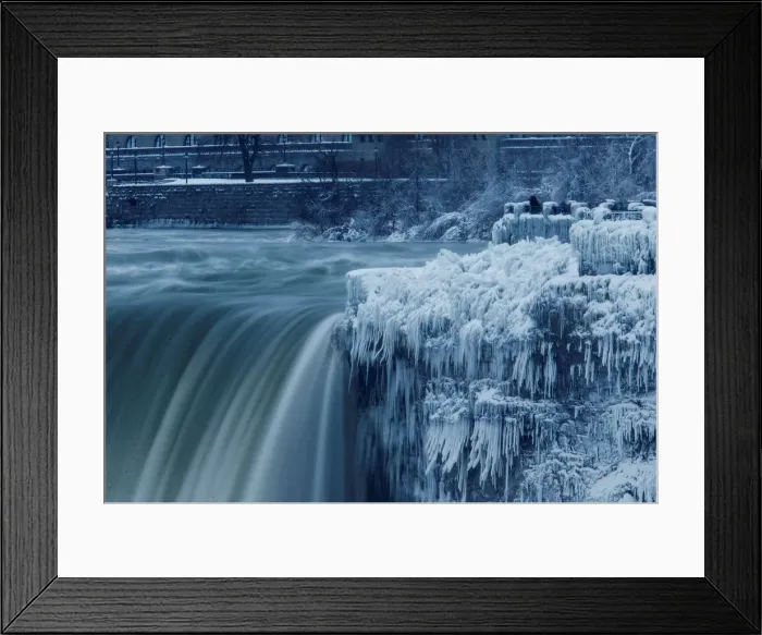 Framed Print : A lone visitor takes a picture near the brink of the ice covered Horseshoe Falls in
