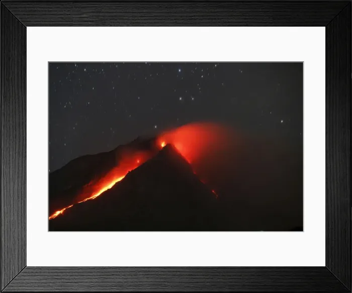 Framed Print : Mount Sinabung volcano spews hot lava as seen from an empty village inside the danger