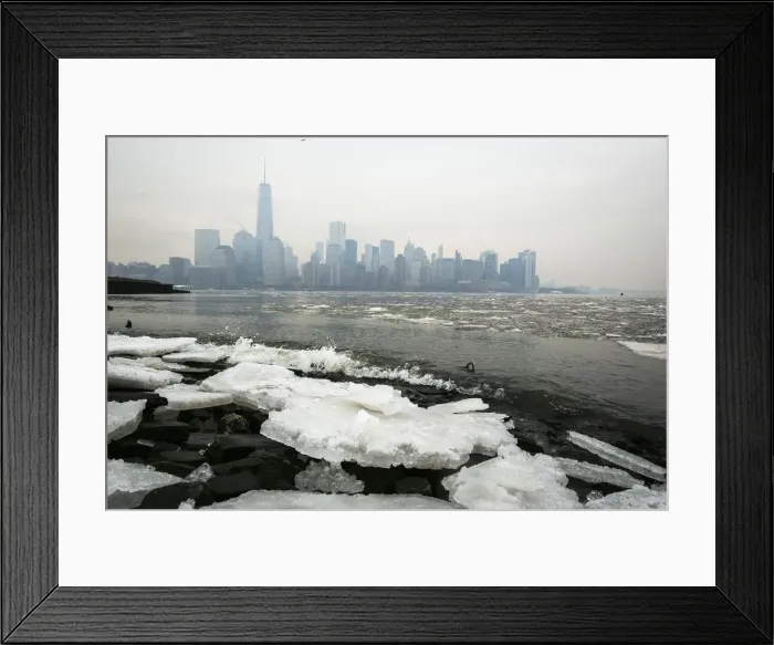Framed Print : Ice lines the shoreline of the Hudson River as the New York City skyline is seen