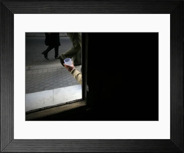 Framed Print : A vagrant begs at the entrance of a church in the Andalusian capital of Seville