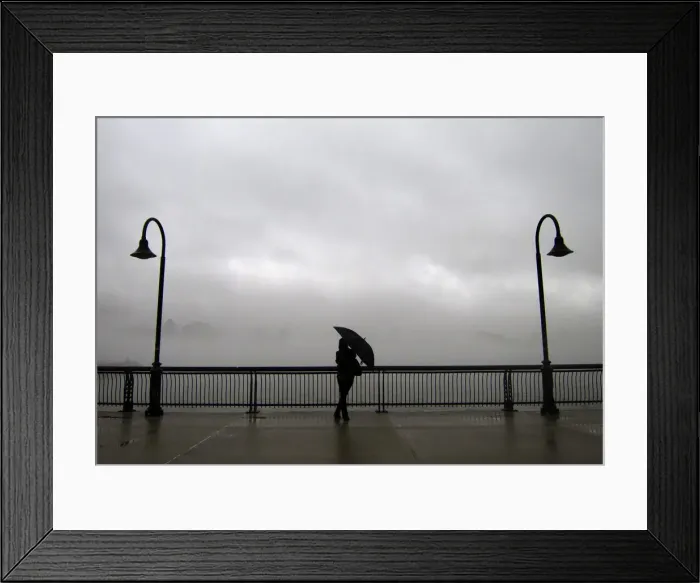 Framed Print : Fog shrouds the skyline of New York as a woman stands next to the Hudson River on a pier Framed Print : Fog shrouds the skyline of New York as a woman stands next to the Hudson River on a pier