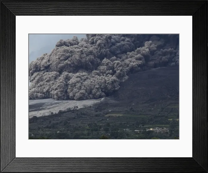 Framed Print : Mount Sinabung volcano spews ash during an eruption, as seen from Berastepu village in