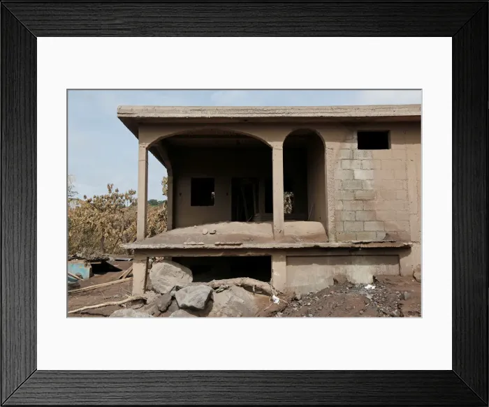 Framed Print : A house damaged by the eruption of the Fuego volcano is seen at San Miguel Los Lotes in