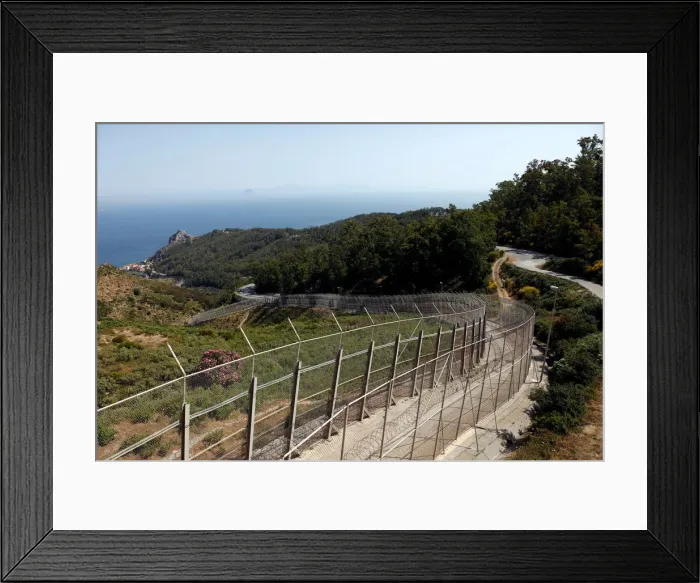 Framed Print : The border fence separating Spains northern enclave Ceuta and Morocco is seen from Ceuta Framed Print : The border fence separating Spains northern enclave Ceuta and Morocco is seen from Ceuta