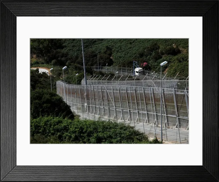 Framed Print : The border fence separating Spains northern enclave Ceuta and Morocco is seen from Ceuta Framed Print : The border fence separating Spains northern enclave Ceuta and Morocco is seen from Ceuta