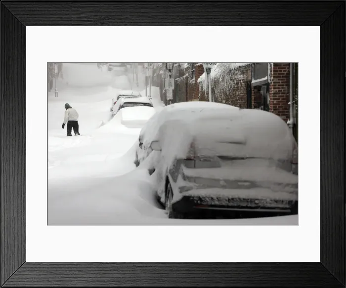 Framed Print : A woman walks up a snow filled street in Boston