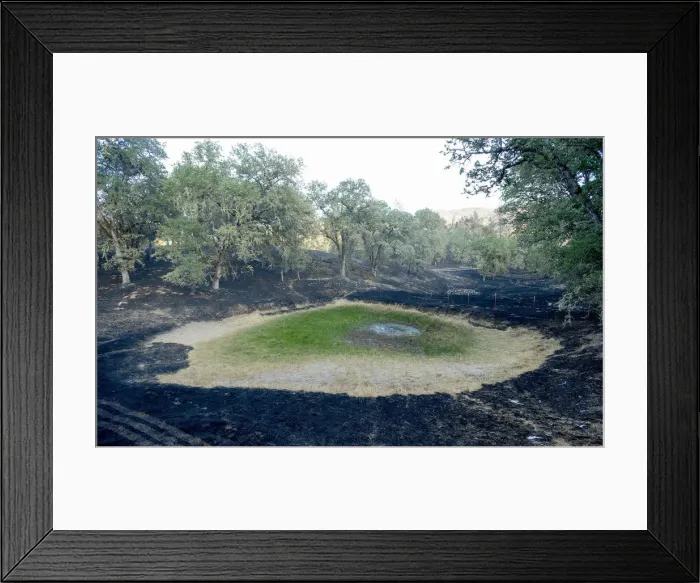 Framed Print : A drained pond sits surrounded by scorched land after the the Butts fire burned through