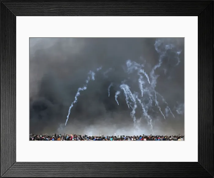 Framed Print : Tear gas canisters are fired by Israeli troops at Palestinian demonstrators during Framed Print : Tear gas canisters are fired by Israeli troops at Palestinian demonstrators during