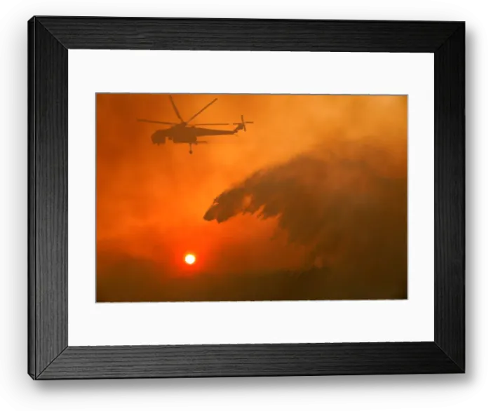 Framed Print : A firefighting helicopter makes water drop as a wildfire burns near the village of Framed Print : A firefighting helicopter makes water drop as a wildfire burns near the village of