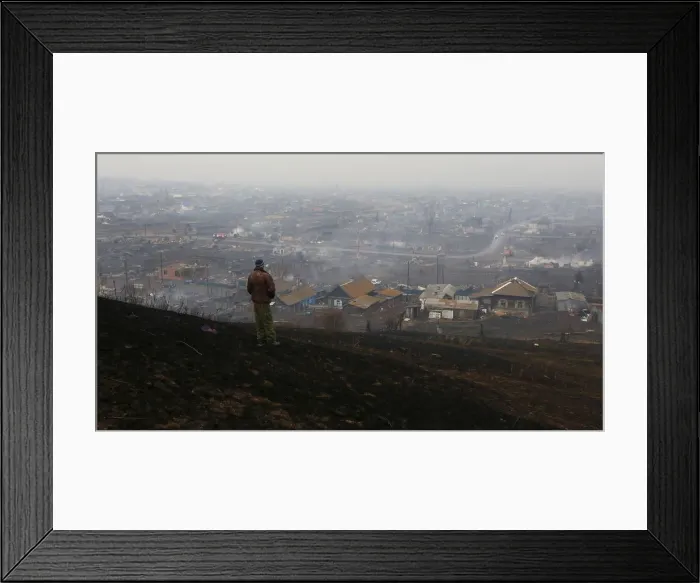 Framed Print : Man looks downhill at the settlement of Shyra, damaged by recent wildfires