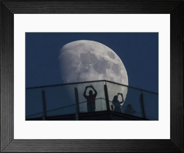 Framed Print : Visitors stand on the roof of a skyscraper as the moon rises over the skyline of Pudong Framed Print : Visitors stand on the roof of a skyscraper as the moon rises over the skyline of Pudong