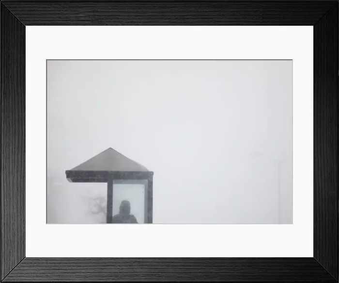 Framed Print : A man waits for a bus during a blizzard in Long Beach