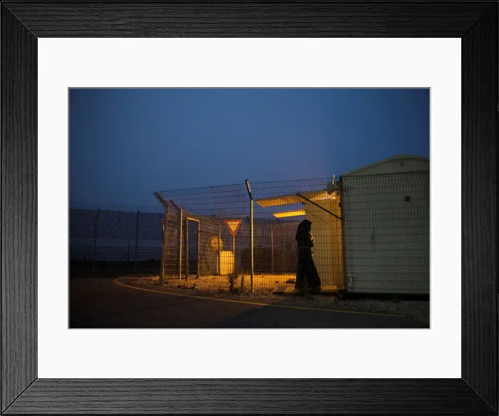 Framed Print : A Syrian woman holds a baby as she walks into a checking room just after they crossed