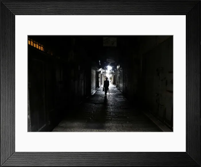 Framed Print : A man walks past closed shops as Palestinian political parties call for a general strike Framed Print : A man walks past closed shops as Palestinian political parties call for a general strike