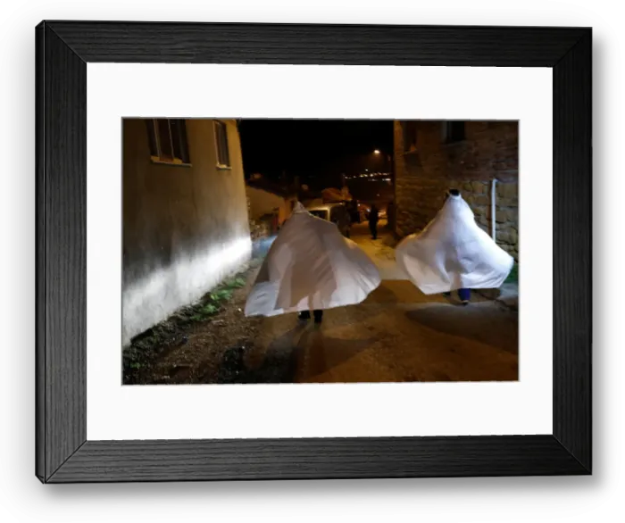 Framed Print : Revellers wrapped in white sheets walk during the aeBocuk nightA Framed Print : Revellers wrapped in white sheets walk during the aeBocuk nightA