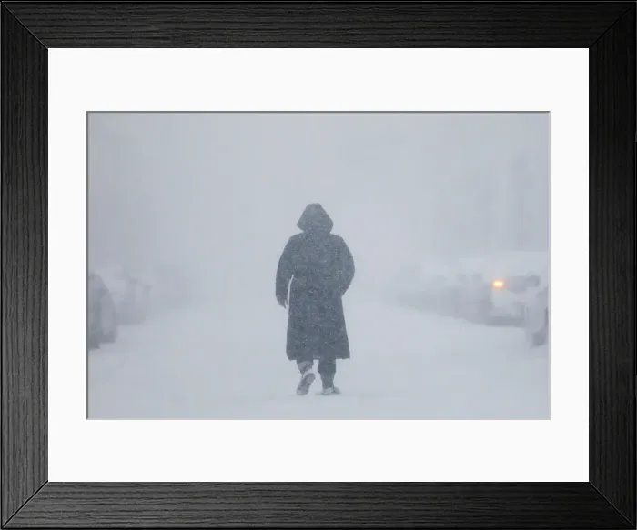 Framed Print : A woman walks down the street during a blizzard in Long Beach Framed Print : A woman walks down the street during a blizzard in Long Beach