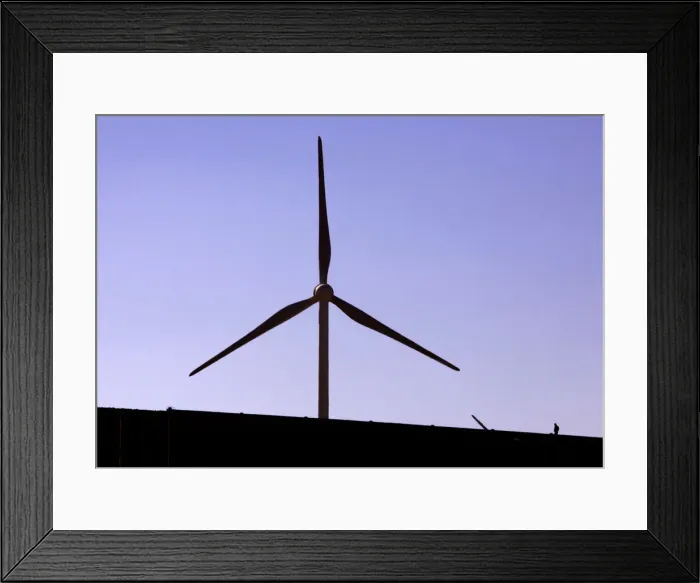 Framed Print : A construction worker walks on a new road located near a field of giant wind turbines Framed Print : A construction worker walks on a new road located near a field of giant wind turbines