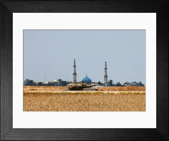 Framed Print : An Israeli tank is seen on the Israeli side of the border fence between Israel Framed Print : An Israeli tank is seen on the Israeli side of the border fence between Israel