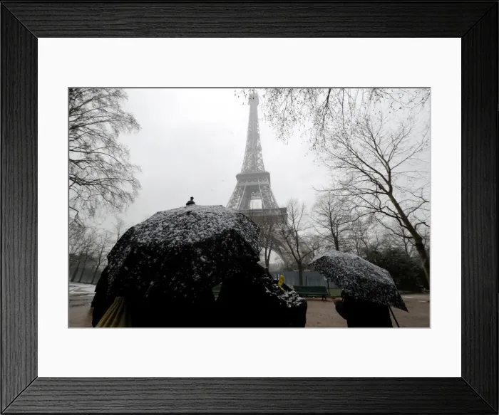 Framed Print : People use umbrellas to take cover from falling snow near the Eiffel Tower in Paris Framed Print : People use umbrellas to take cover from falling snow near the Eiffel Tower in Paris