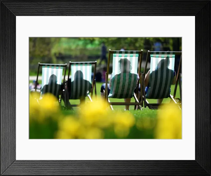 Framed Print : People are silhouetted against the fabric of deckchairs as they enjoy the sunshine in St Framed Print : People are silhouetted against the fabric of deckchairs as they enjoy the sunshine in St