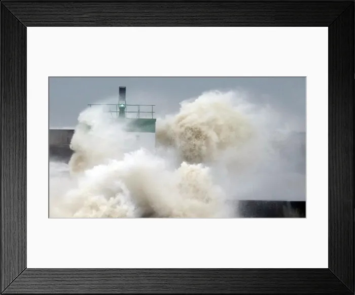 Framed Print : A wave breaks near the lighthouse in Biarritz, southwestern France