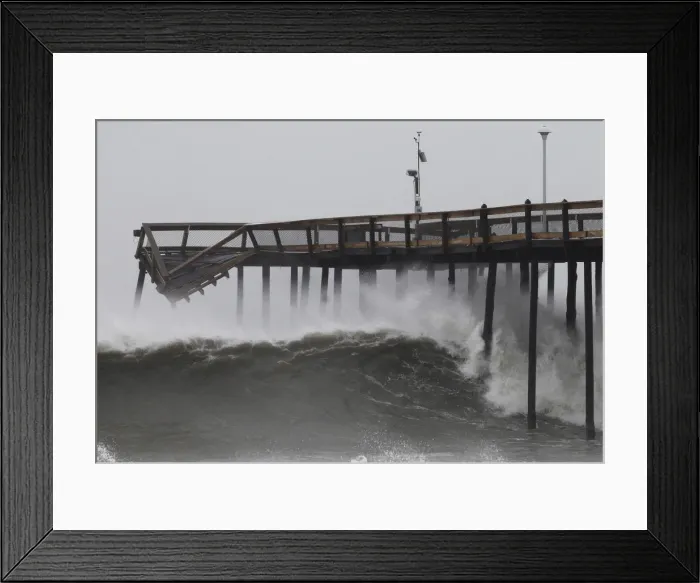 Framed Print : Waves break along the pier which was damaged during Hurricane Irene, in Ocean City