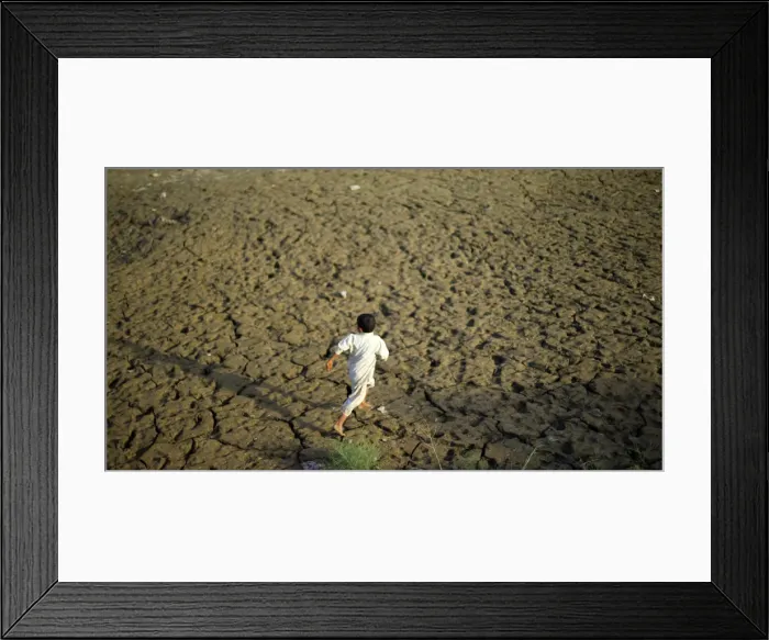 Framed Print : A young flood victim runs as he plays at a relief camp in Mohib Banda near Charsadda