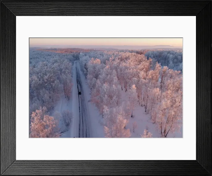 Framed Print : An aerial view shows a car driving along a forest road during sunset in the Siberian Framed Print : An aerial view shows a car driving along a forest road during sunset in the Siberian