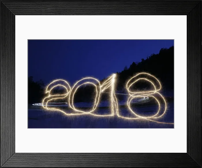 Framed Print : The numbers 2018 are written in the air with a sparkler on a roadside while cars drive Framed Print : The numbers 2018 are written in the air with a sparkler on a roadside while cars drive