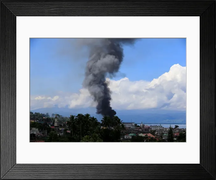 Framed Print : Smoke billows from a burning building in Marinaut village as government troops continue Framed Print : Smoke billows from a burning building in Marinaut village as government troops continue