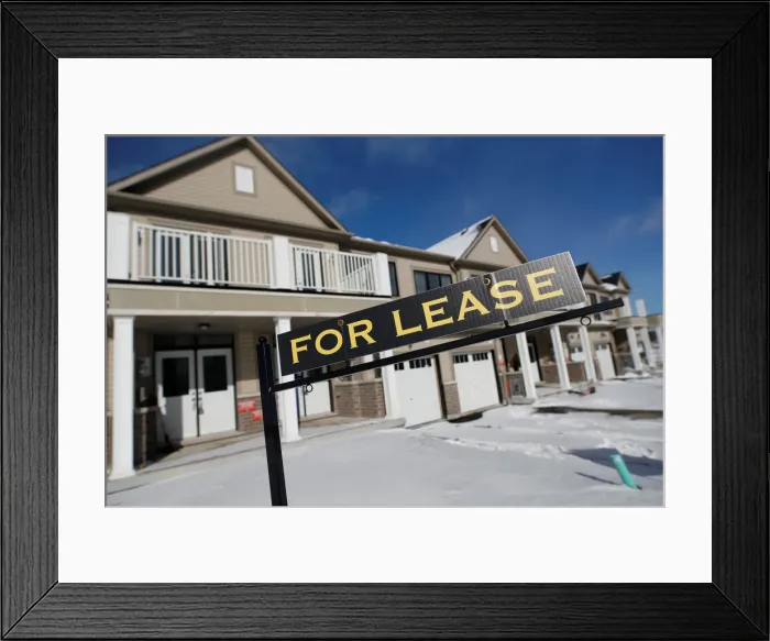 Framed Print : A For lease sign stands in front of a row of houses in a newly build subdivision in Framed Print : A For lease sign stands in front of a row of houses in a newly build subdivision in