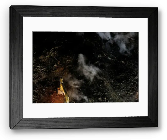 Framed Print : Excavator removes debris of a building that caught fire