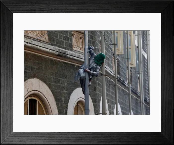 Framed Print : A worker paints a lamp post on a street in Mumbai Framed Print : A worker paints a lamp post on a street in Mumbai