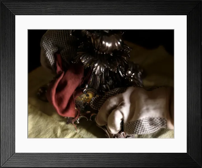 Framed Print : A woman polishes an antique silver candelabra at her home in Valletta