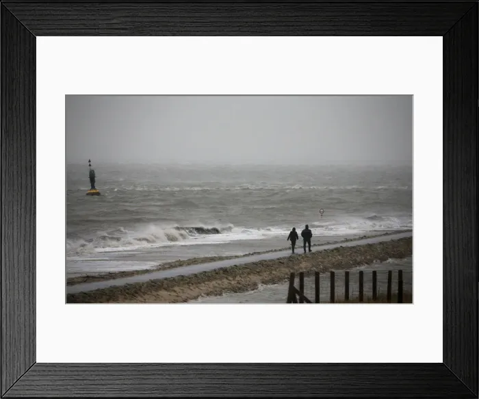 Framed Print : People walk on a beach at the North Sea in Cuxhaven Framed Print : People walk on a beach at the North Sea in Cuxhaven