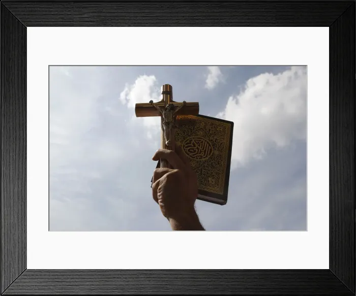 Framed Print : An Egyptian holds up a Koran and a cross during a rally to demonstrate the unity between Framed Print : An Egyptian holds up a Koran and a cross during a rally to demonstrate the unity between
