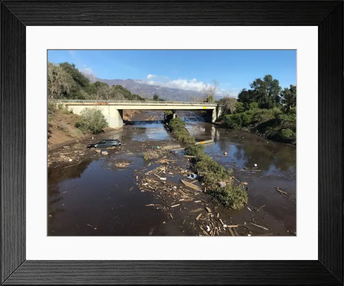 Framed Print : An abandoned car is seen stuck in flooded water on the 101 freeway after a mudslide in Framed Print : An abandoned car is seen stuck in flooded water on the 101 freeway after a mudslide in