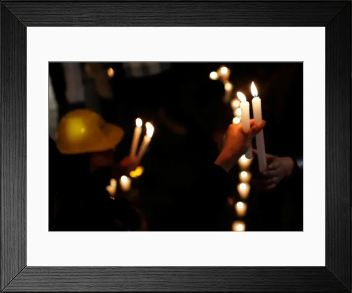 Framed Print : Earthquake victim holds a candle to mark the four-month anniversary of the September 19