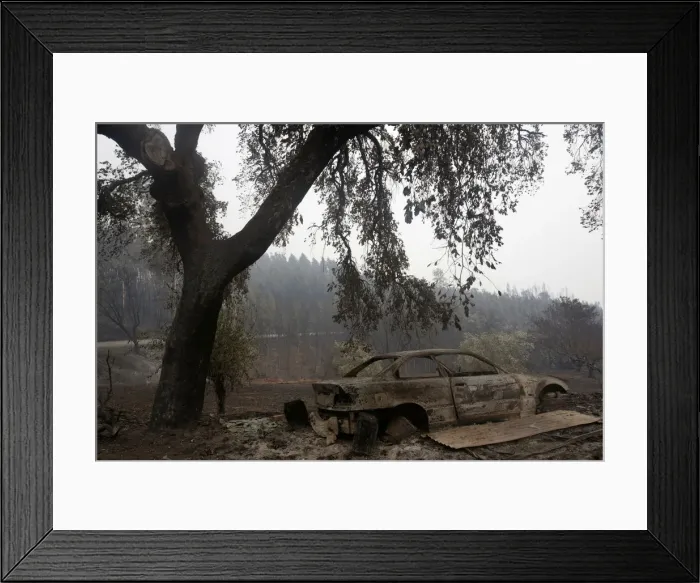 Framed Print : A burned car is seen in a local road following a forest fire outside Pedrogao Grande Framed Print : A burned car is seen in a local road following a forest fire outside Pedrogao Grande