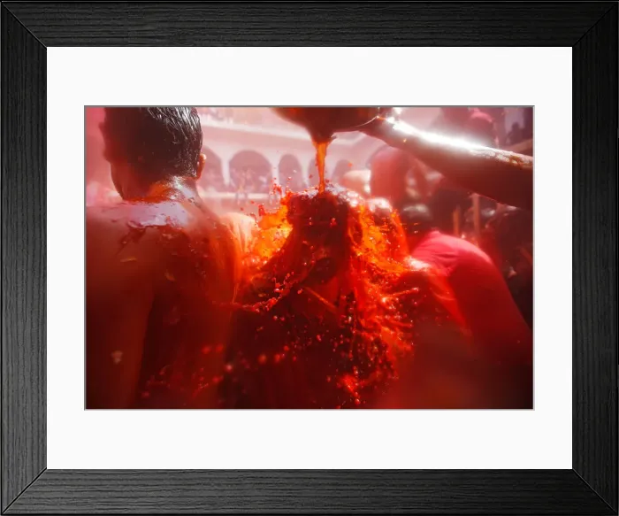 Framed Print : A man throws water on a woman during Huranga, a game played between men Framed Print : A man throws water on a woman during Huranga, a game played between men