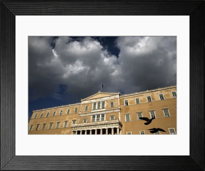 Framed Print : A Greek national flag flutters atop the parliament building in Athens