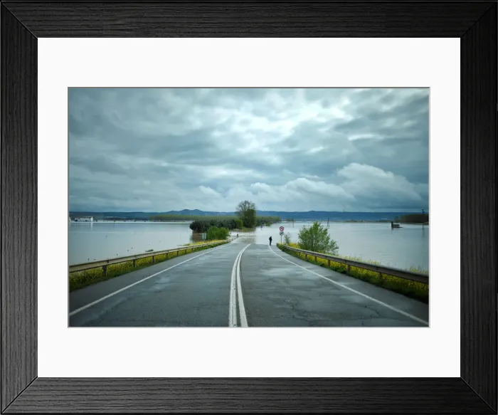Framed Print : A man stands on a road flooded by waters from the River Ebro Framed Print : A man stands on a road flooded by waters from the River Ebro