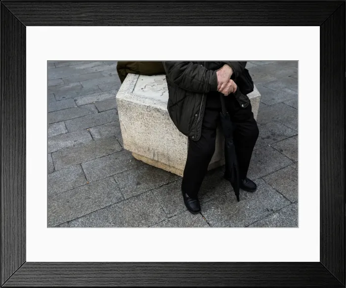 Framed Print : A man sits on the street in central Madrid Framed Print : A man sits on the street in central Madrid